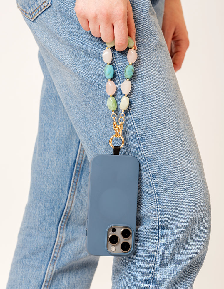 coque iPhone bleue et bijou de téléphone perles